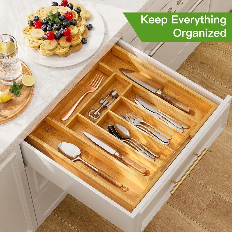 Signature bamboo drawer organizer holding cutlery in a white kitchen drawer