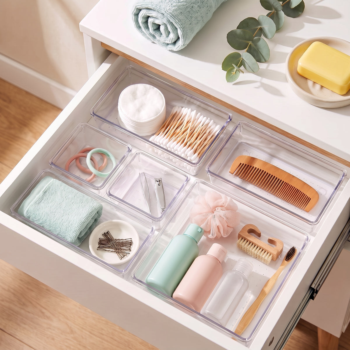 Clear trays organizing toiletries in a bathroom drawer